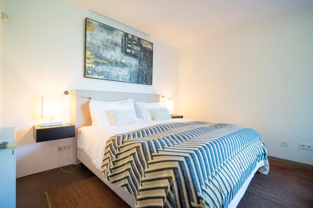 Dormitorio en suite de la villa con salida al jardín y piscina