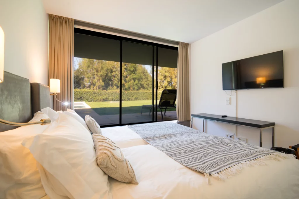 Luminoso dormitorio en suite de la villa con salida al jardín y piscina