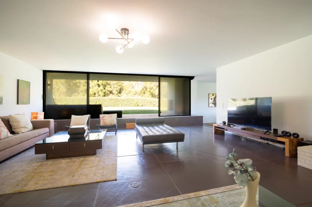 Salón con ventanal y acceso a la piscina y jardín de la villa Bom Sucesso